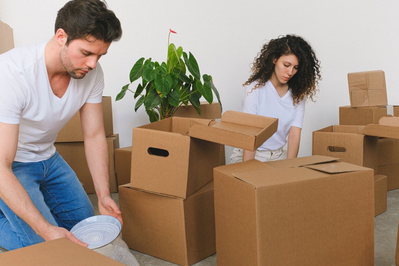 A couple unpacking moving boxes in a bright new home