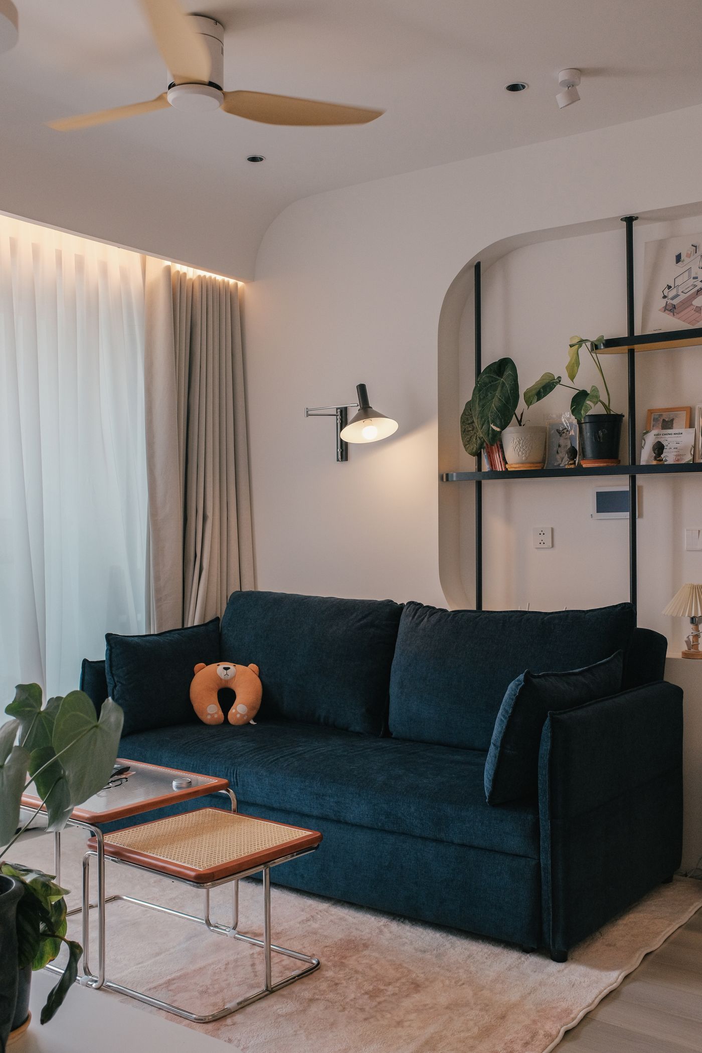Cozy, tidy living room with a teal sofa and warm lamplight